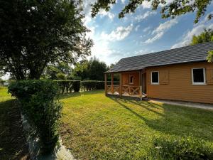 a small cabin with a yard and a fence at Chalet dans le Perche in Soligny-la-Trappe
