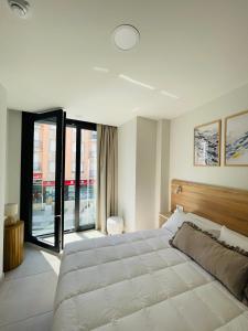 a bedroom with a large bed and a large window at Apartamentos Limar Portonovo - Sanxenxo in Portonovo