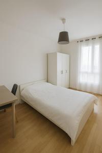 a white bedroom with a large bed and a desk at Appartement spacieux de 100m2 Brest in Brest