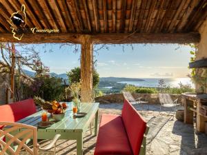 a patio with a table and chairs and a view of the ocean at Villa Acciagina 10 pers PISCINE VUE MER PINARELLO Climatisée in Pinarellu