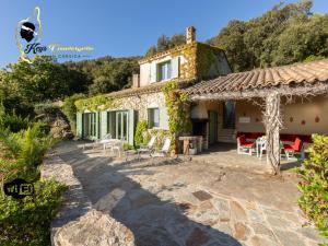 a stone house with a garden and a patio at Villa Acciagina 10 pers PISCINE VUE MER PINARELLO Climatisée in Pinarellu