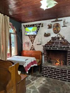 a room with a fireplace and a table and a piano at Villa Zefi Rrenc in Shkodër