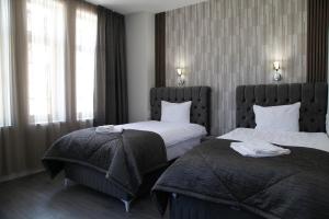 ein Hotelzimmer mit zwei Betten und einem Fenster in der Unterkunft Corner House in Lowetsch + 88 Fotos