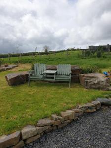 two benches sitting on the grass in a field at Pondside Cabin in Launceston +3 photos