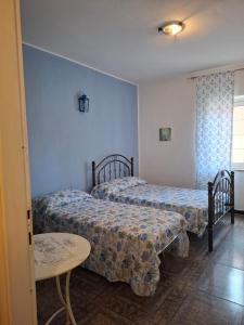 a bedroom with two beds and a table and a window at Pintadera in San Giovanni +11 photos