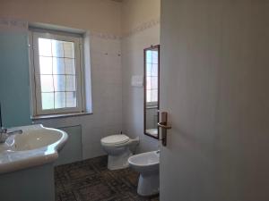 a bathroom with a sink and a toilet and a window at Pintadera in San Giovanni
