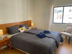 a bedroom with a large bed with blue towels on it at Apartment Ricardo-200m zum Meer in Armação de Pêra