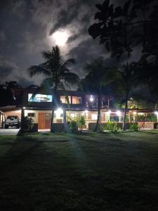 a house lit up at night with a palm tree at Apartamento Il Defino #1 in Pavones
