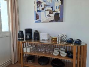 a wooden shelf with cups and dishes on it at L'hirondelle bleue in Tunis