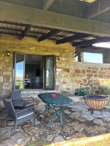 a patio with a table and chairs on a stone wall at La Vista Farm Stay in Ermelo +7 photos