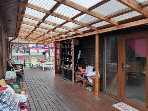 a wooden deck with a pergola and a living room at Roberto ranch in Palanga