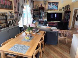 a dining room and living room with a wooden table at Roberto ranch in Palanga