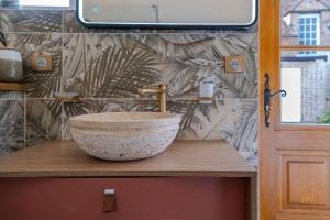 un bagno con un lavandino a ciotola su un bancone di Jacuzzi Maison 15min Parc Fédéral Lamotte-Beuvron Caution OBLIGATOIRE swikly a La Ferté-Beauharnais Altre 25 foto