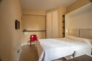 1 dormitorio con 1 cama y 1 silla roja en Minimal Signoria, en Florencia