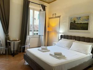 a bedroom with a large white bed with a window at Fashion Florence Rooms in Florence