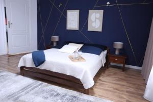 a bedroom with a bed with a blue wall at The Castle Terrace Apartment 100m2 in Ciechanów +70 photos