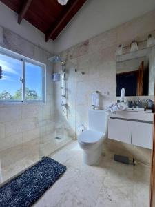 Un baño con inodoro, lavabo y ducha. en Sosua Residence by CJDR, en Sosúa