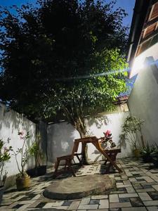 een houten bank op een binnenplaats met een boom bij Dream Villa Homestay Madiha in Matara +9 foto's