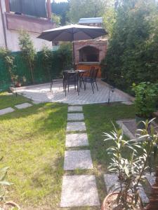 a patio with a table and chairs and an umbrella at Orhideja Visoko in Visoko