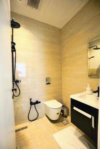 a bathroom with a shower and a toilet and a sink at Luxury 2BR Close to Boulevard extra maid room in Riyadh