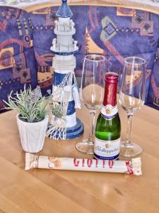 - une table avec 2 verres et une bouteille de vin dans l'établissement Dünenlounge Dornumersiel, à Dornum