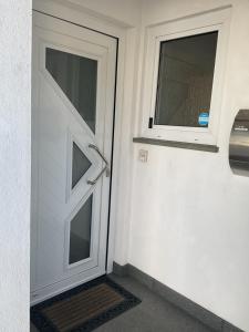 une porte avec une fenêtre sur le côté du bâtiment dans l'établissement Gästezimmer Fischbach, à Kelkheim