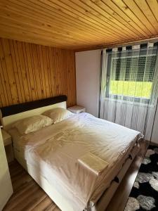 a bedroom with a large bed with a window at Weekend getaway house in Goražde