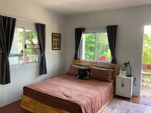 a bed in a bedroom with two windows at Sea Salt 2 Cozy Studio with full kitchen and Fast Wifi in Thong Sala