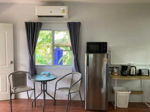 a kitchen with a table and chairs and a refrigerator at Sea Salt 2 Cozy Studio with full kitchen and Fast Wifi in Thong Sala