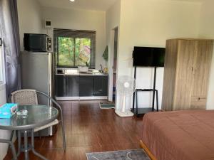 a living room with a bed and a table and a kitchen at Sea Salt 2 Cozy Studio with full kitchen and Fast Wifi in Thong Sala +5 photos