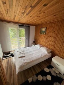 a bedroom with a large bed with a wooden ceiling at Weekend getaway house in Goražde