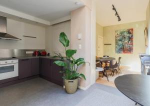 eine Küche mit einer Topfpflanze und einem Tisch in der Unterkunft Charming Family Townhouse in Antwerp in Antwerpen