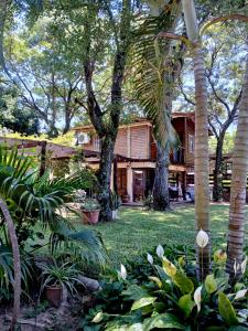 a house with trees and plants in front of it at Cabañas Costa Santino in Ituzaingó