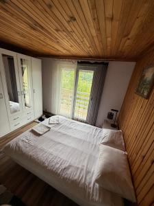 a bedroom with a large bed with a wooden ceiling at Weekend getaway house in Goražde