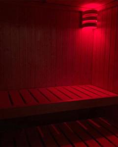 a red room with a bench with a red light at Natura e spa in Cairo Montenotte +6 photos
