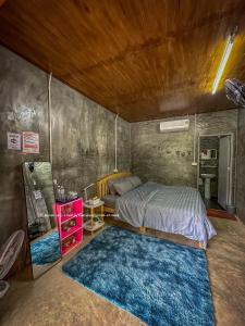 Un dormitorio con una cama y una alfombra azul. en Kan-ang Homestay Maekampong, en Ban Pok Nai