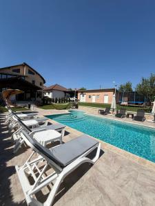 a row of lounge chairs next to a swimming pool at Căsuța bunicii in Tureni