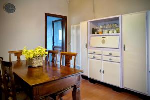 a dining room with a table and a white cabinet at La Casa del Voltone in Pontremoli