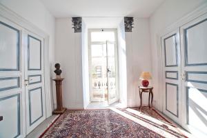 a hallway with an open door and a table with a lamp at Roman Holidays cuore dell'Impero in Rome