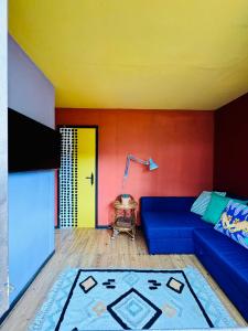 a living room with a blue couch and a yellow wall at Mexican House in Cortesia