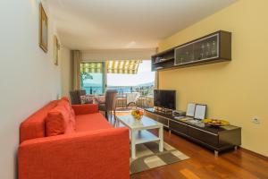 a living room with a red couch and a table at Apartments Villa Dinka in Opatija