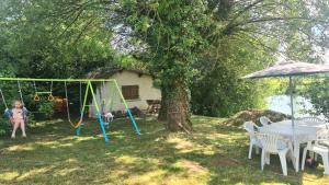 a child playing on a swing set in a yard at La Barkalo in Autet
