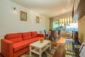 a living room with a red couch and a table at Apartments Villa Dinka in Opatija