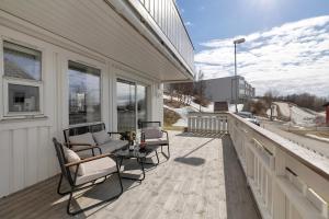 una veranda con sedie e tavolo su una casa di Casa Reinen a Trondalen