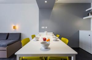 a dining room with a white table and yellow chairs at Résidence Le Varet - Arcs 2000 in Arc 2000