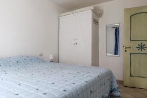 a bedroom with a bed and a blue door at Portopollo Apartment in Porto Pollo +56 photos