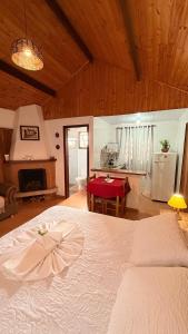 a bedroom with a white bed and a fireplace at Chalés Raios de Sol in Monte Verde