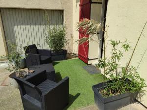 a small garden with grass and chairs and plants at Chambre indépendante avec SDB privative in Avignon