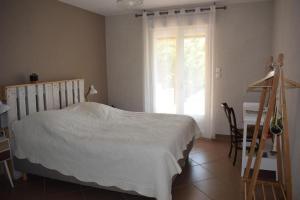 a bedroom with a bed and a desk and a window at Chambre la canauloise in Canaules-et-Argentières