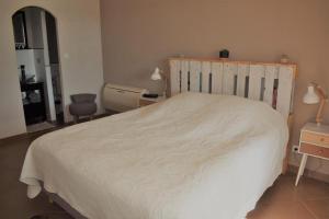 a bedroom with a large white bed and a chair at Chambre la canauloise in Canaules-et-Argentières